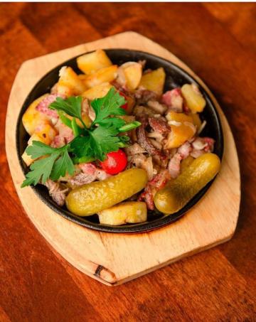 Russe « Zharenko » avec des pommes de terre, de la viande et des saucisses. délicieux